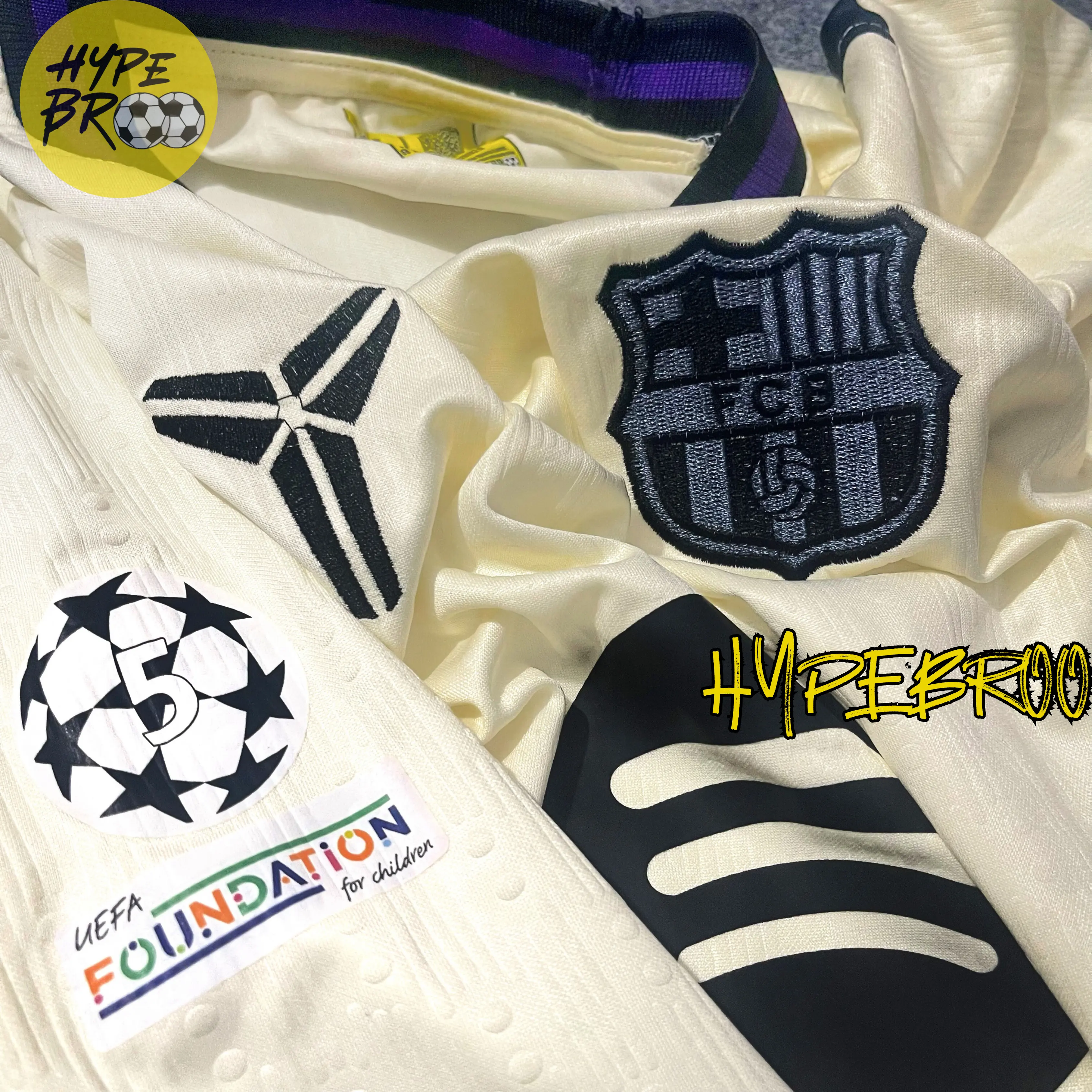 Close-up of Barcelona crest, Kobe Bryant tribute logo, and 5 UCL patch on 2025-26 away kit
