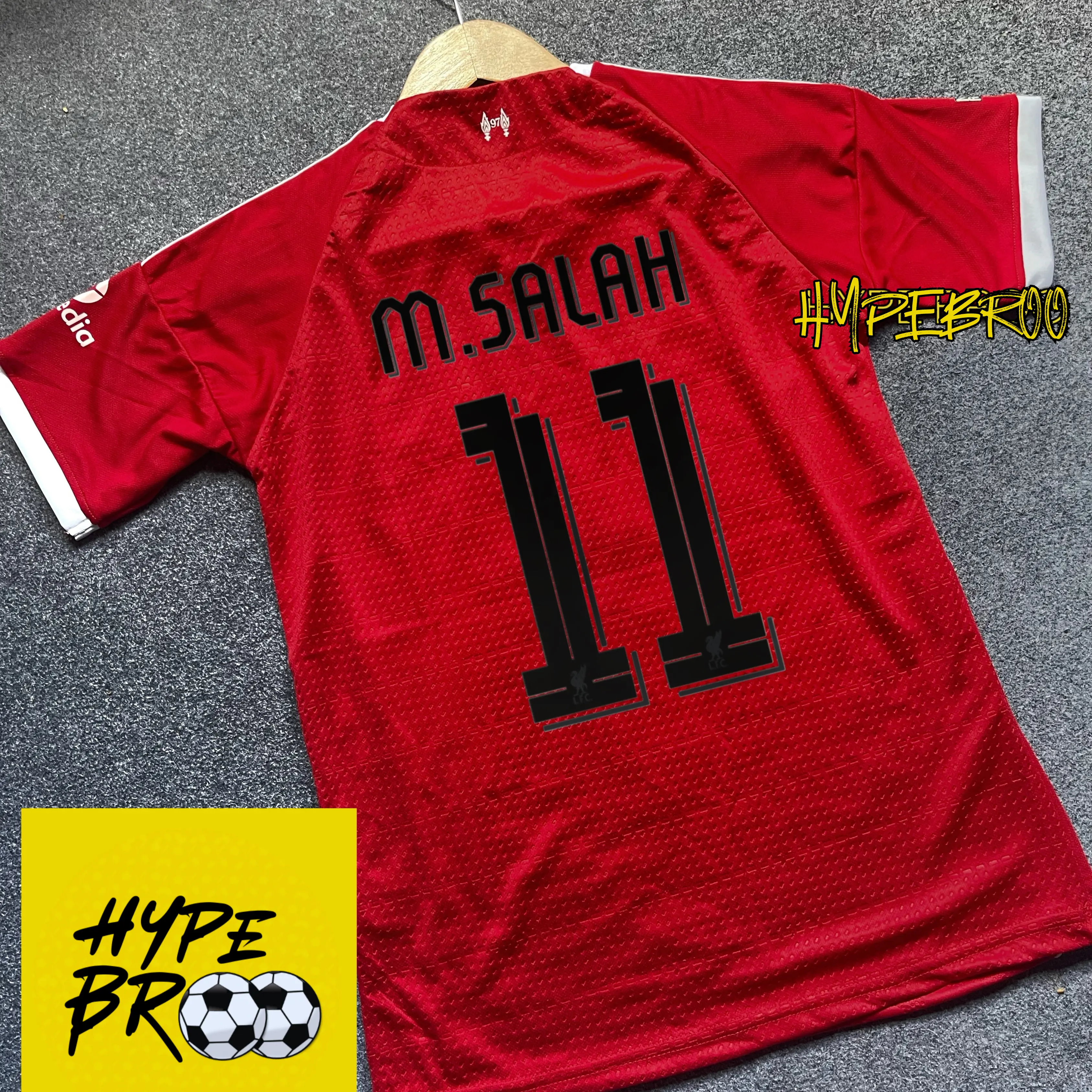 Liverpool 2025-26 home jersey back view laid on carpet with hanger