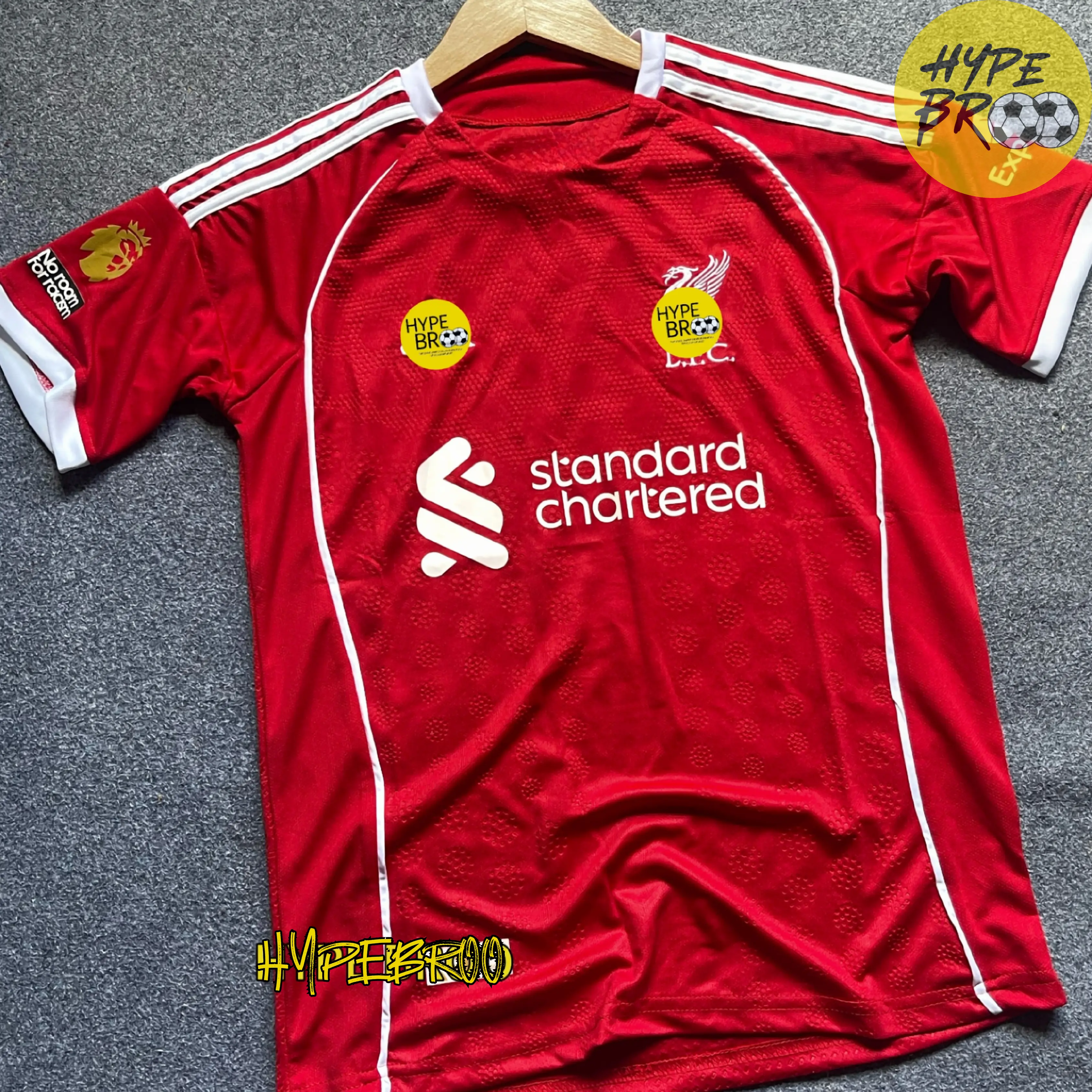Liverpool 2025-26 home jersey front view laid on carpet with hanger