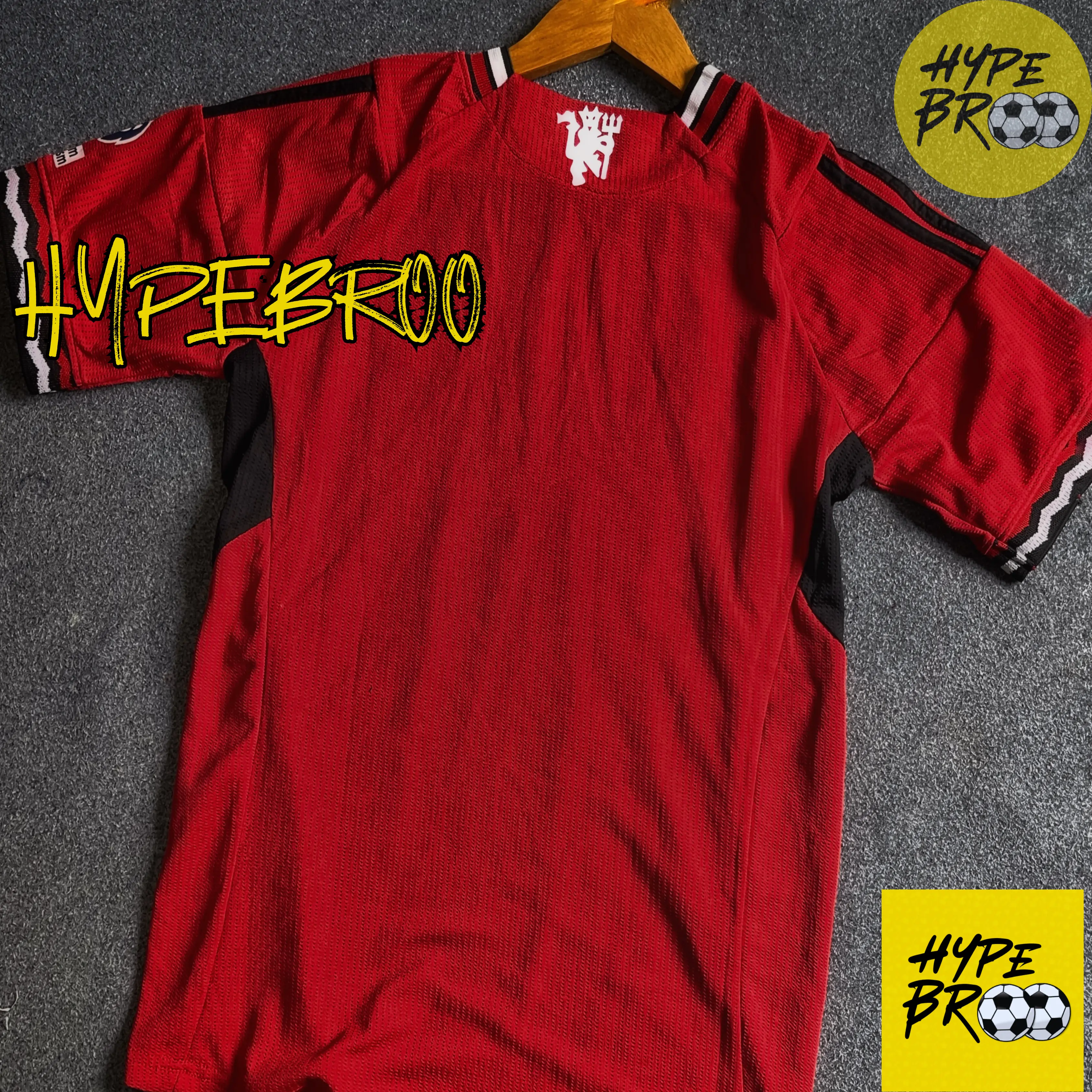 Manchester United 2025-26 home jersey back view laid on carpet with hanger