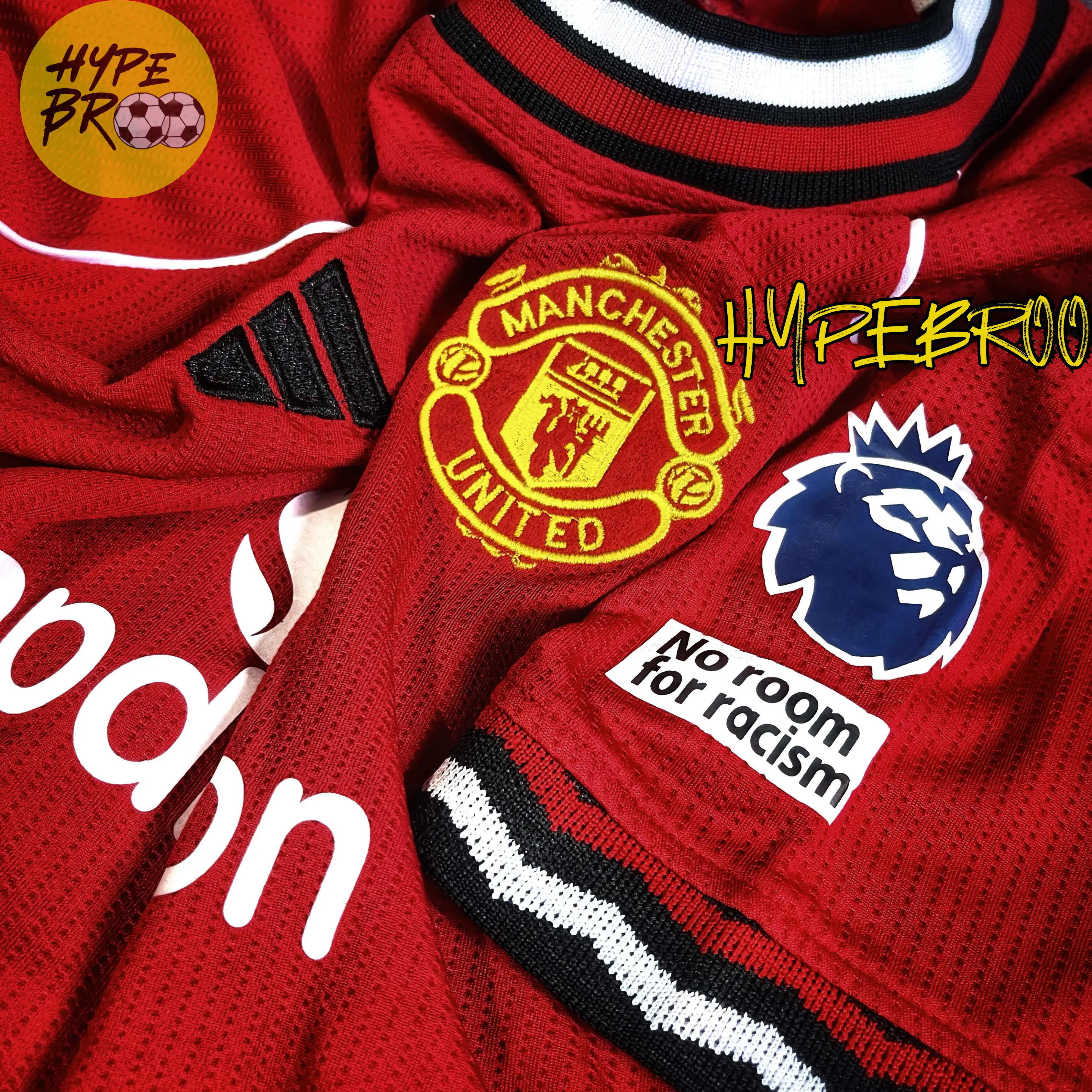 Close-up of Manchester United crest and Adidas logo on 2025-26 home jersey